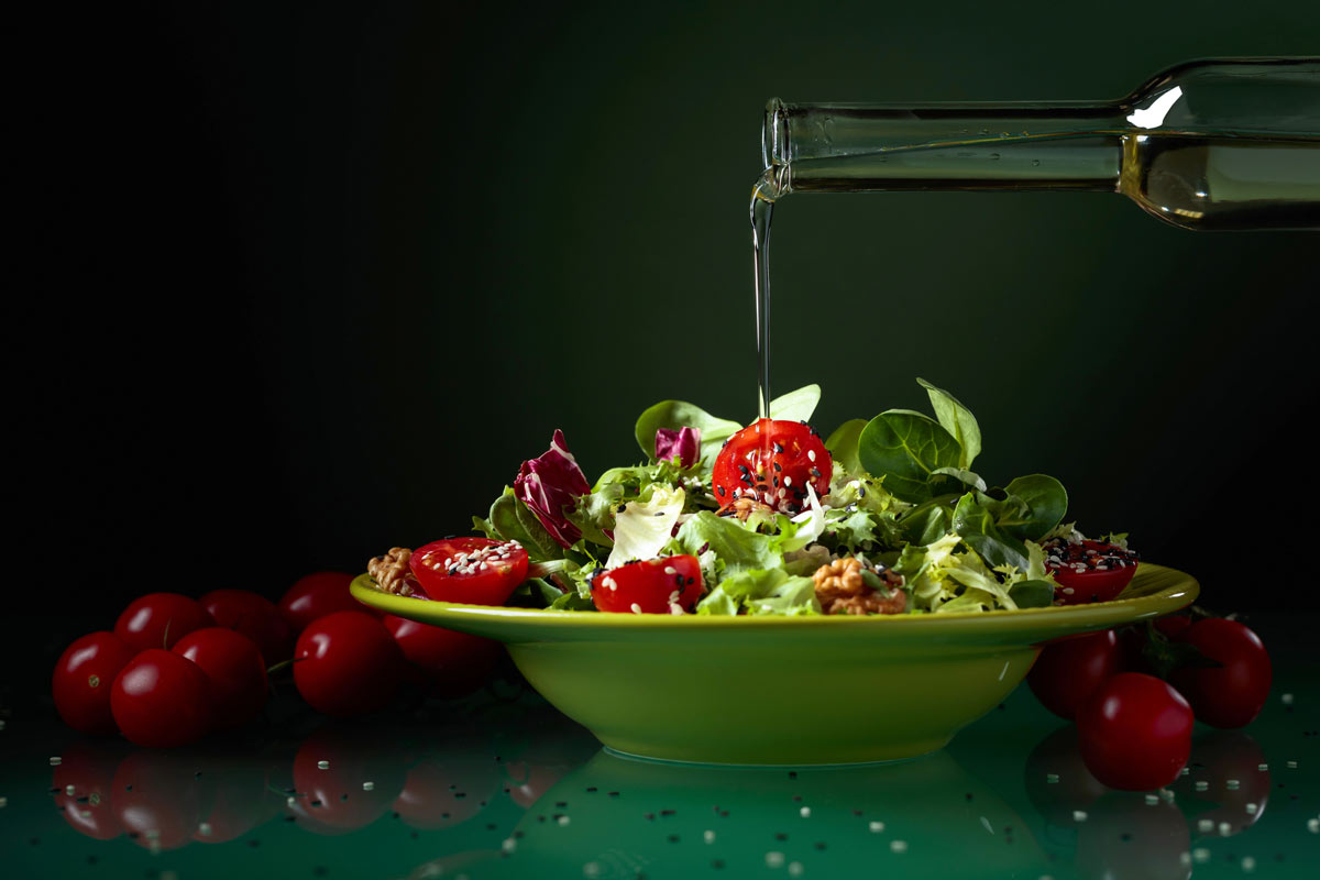 pouring oil over salad